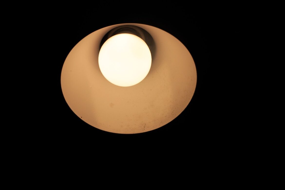 Słabo żarząca się lampa LED po wyłączeniu w ciemnym pokoju